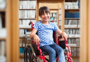 Girl uses a wheelchair in a library