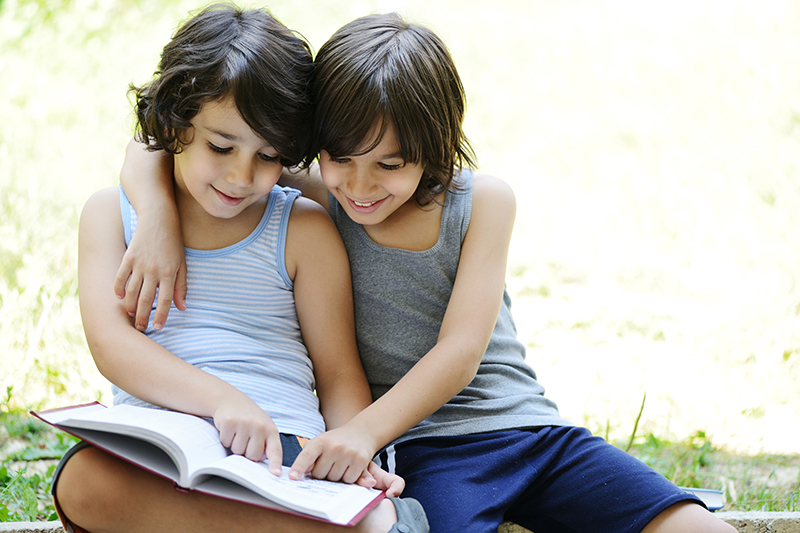 Two boys reading a book