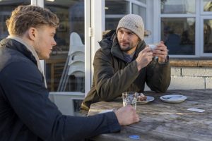 Two young men talking seriously over drinks