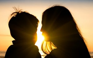 Mother and son silhouetted by the sunset
