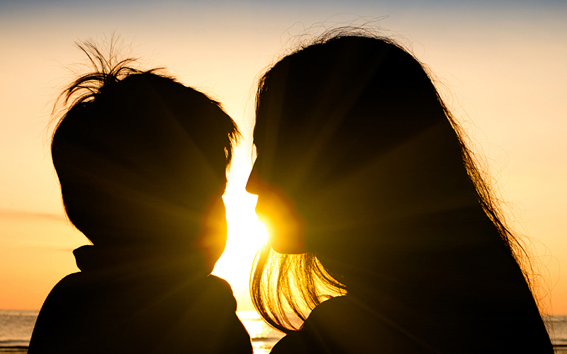 Mother and son silhouetted by the sunset