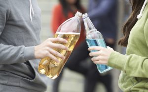 Teenagers hold alcoholic drinks