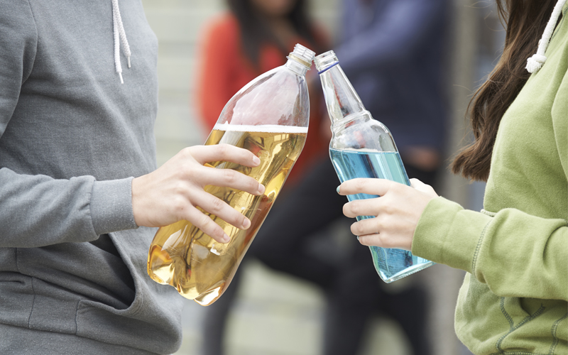 Teenagers hold alcoholic drinks