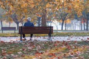 Lonely Senior Man Sitting On Bench In Park