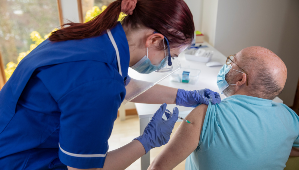 Nurse giving a man the COVID-19 vaccine