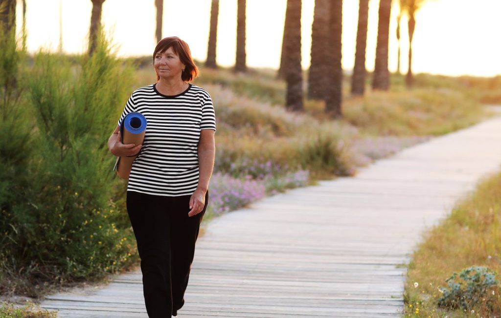Woman walking with yoga mat