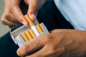 Hand taking cigarette from packet