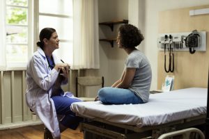 Doctor talking to young patient in hospital