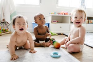 Three babies sitting on mat