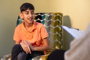 Young boy in orange tshirt at a a therapy session